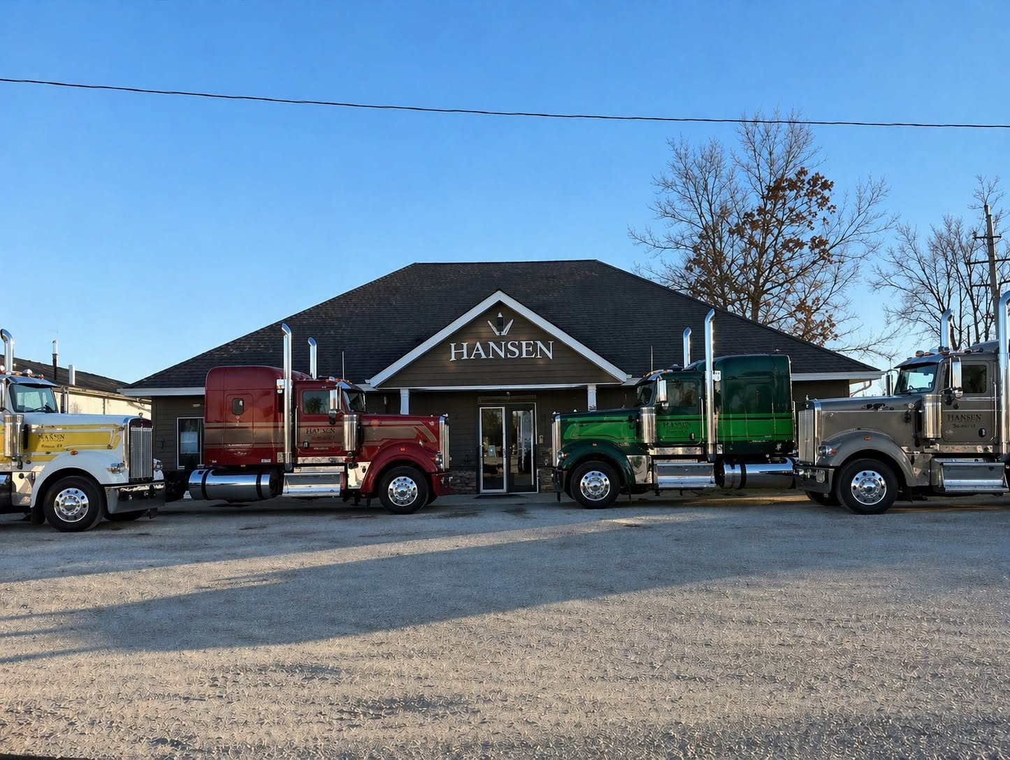 Four Hansen Trucking trucks lined up at the Jerseyville office at golden hour