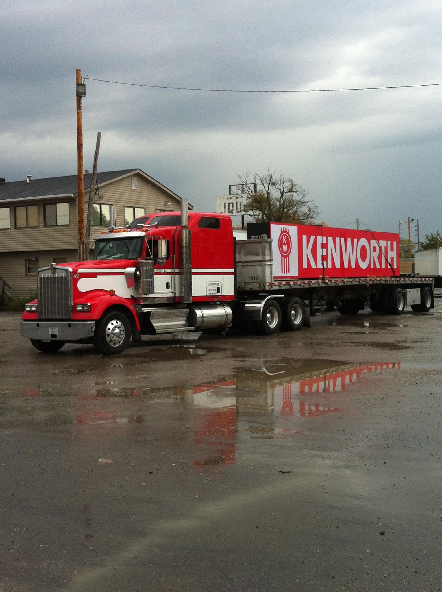 Red Kenworth hauling a Kenworth ad