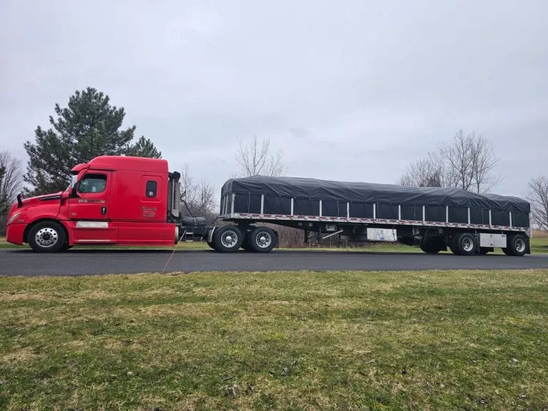 Red Hansen truck with tarped load