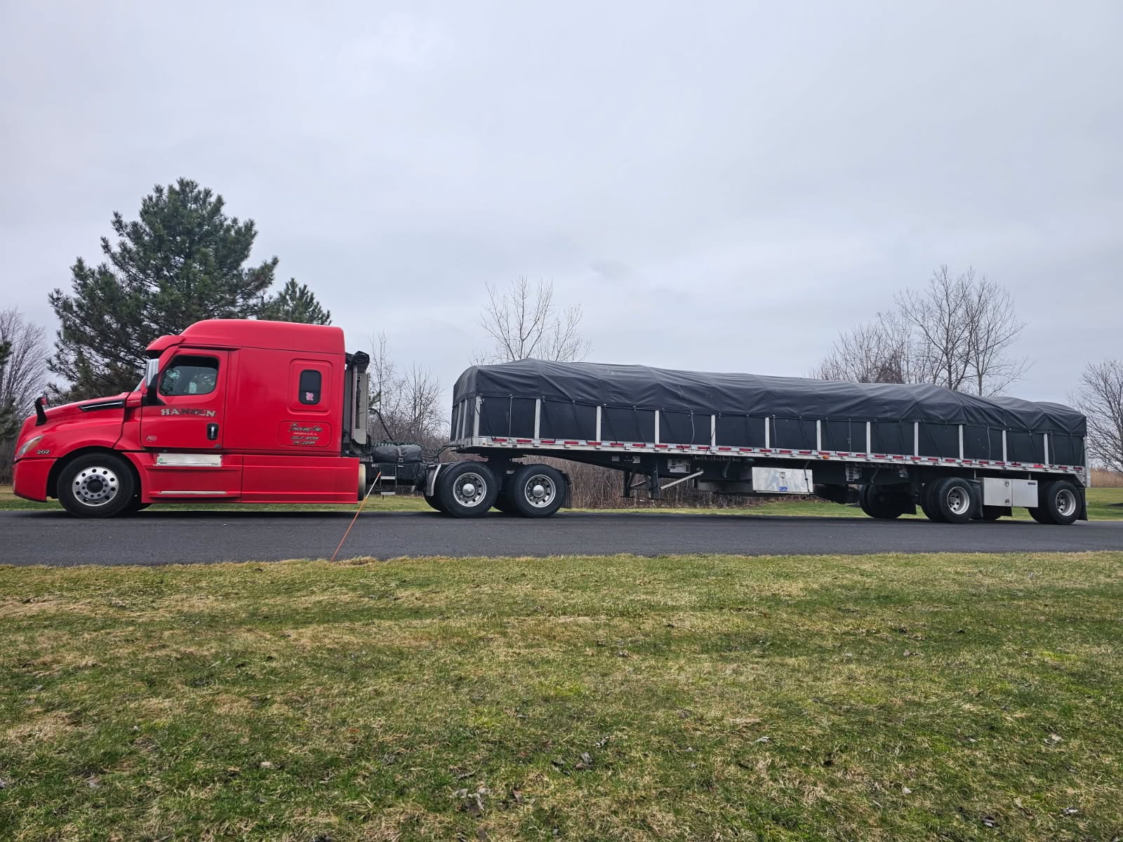 Red Hansen truck with tarped load